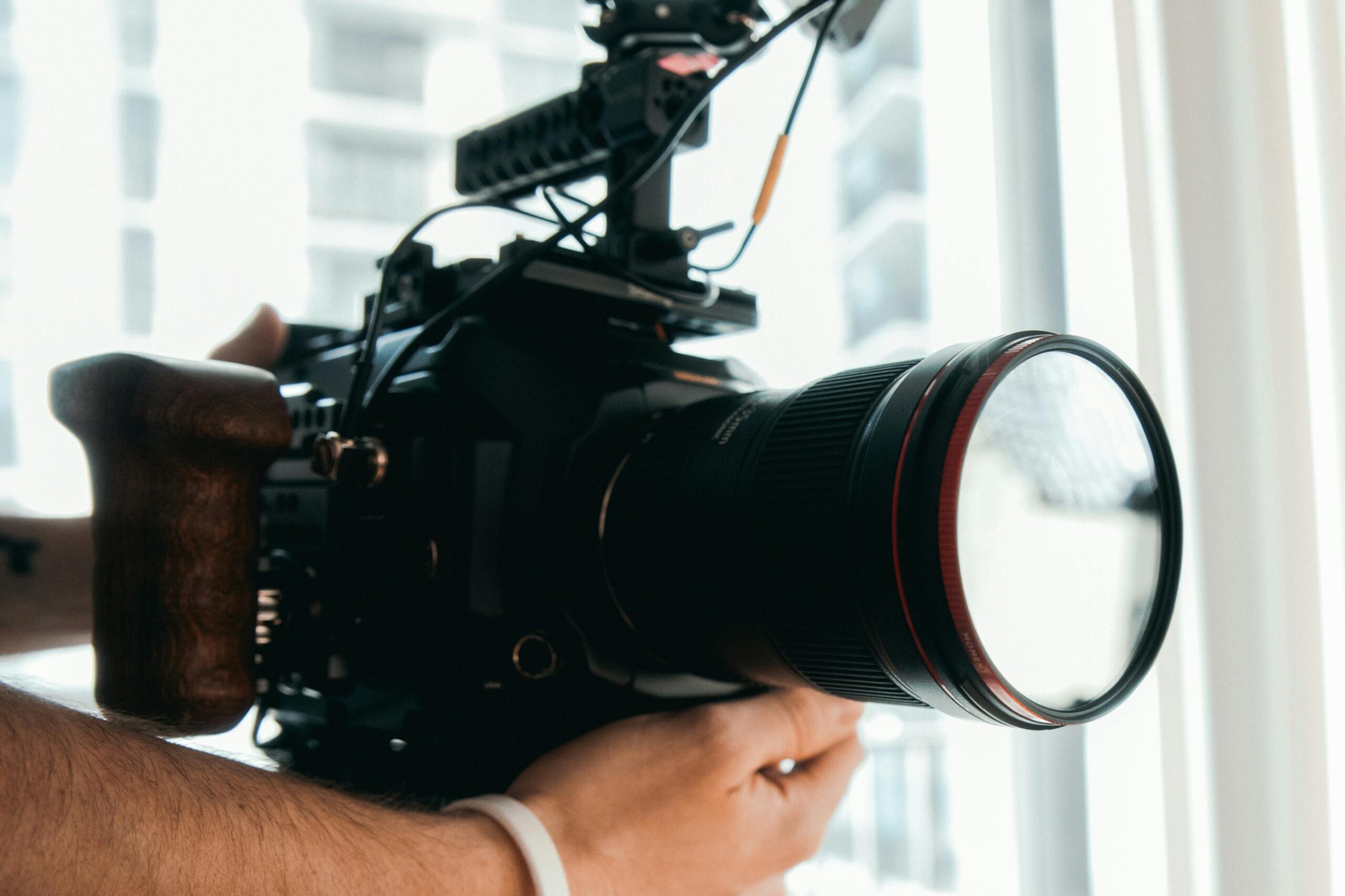 Captivating close-up of a DSLR camera with professional setup, held in hands, ideal for tech enthusiasts.