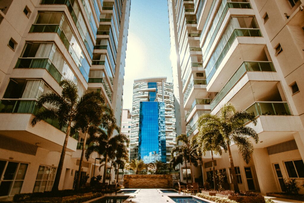 Condo Buying View of modern urban skyscrapers with palm trees, showcasing contemporary architecture.